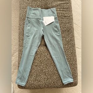 NWT Athleta Salutation Stash pocket 7/8 tights. Color is minimalistic grey, Sz S